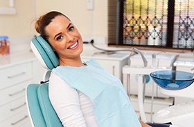 Smiling female dental patient in treatment chair