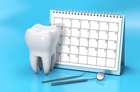 Calendar next to tooth model and dental instruments