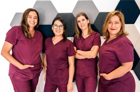 Four happy, smiling dental team members